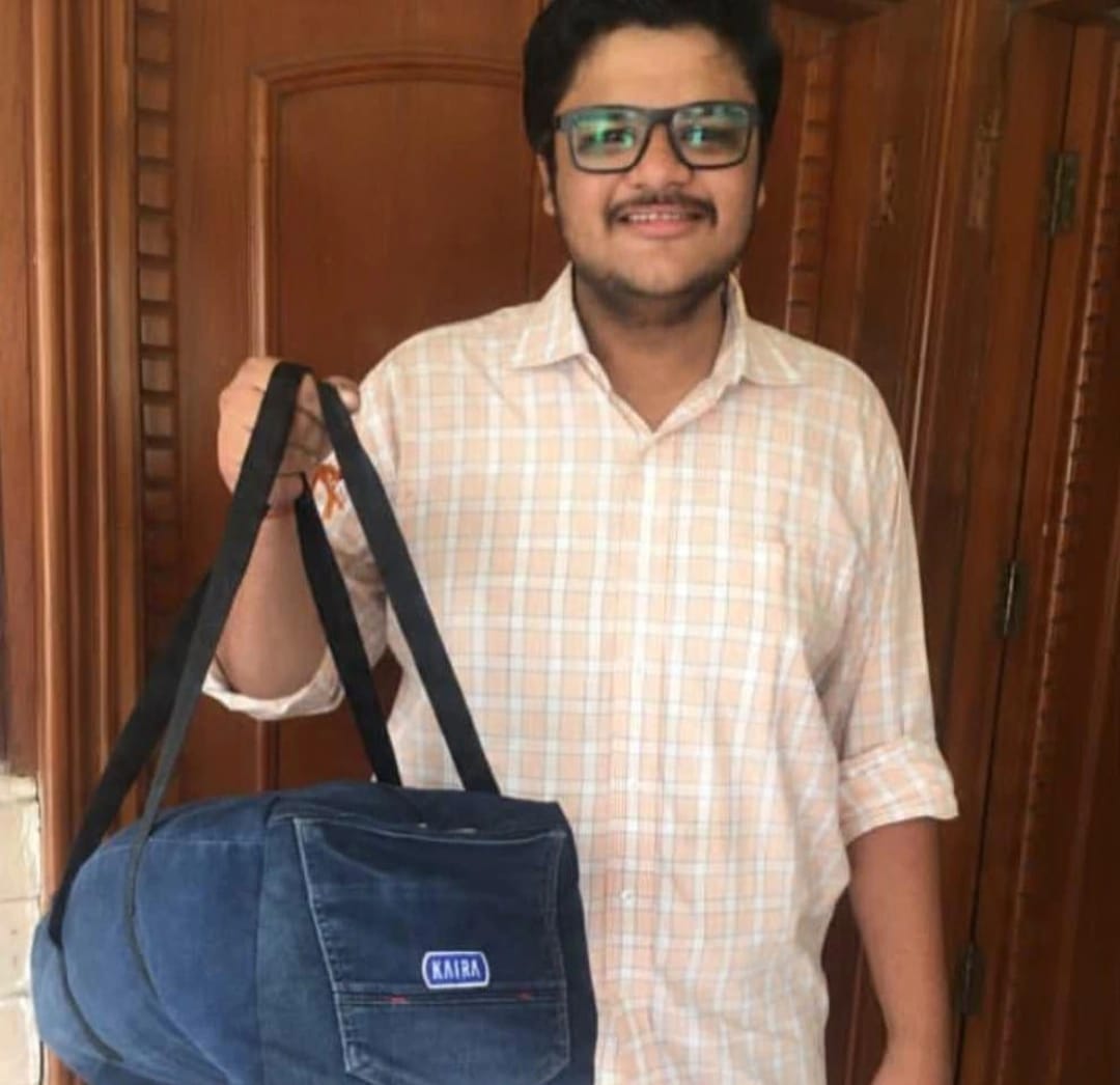 Customer holding a compact denim duffle bag with a KAIRA label