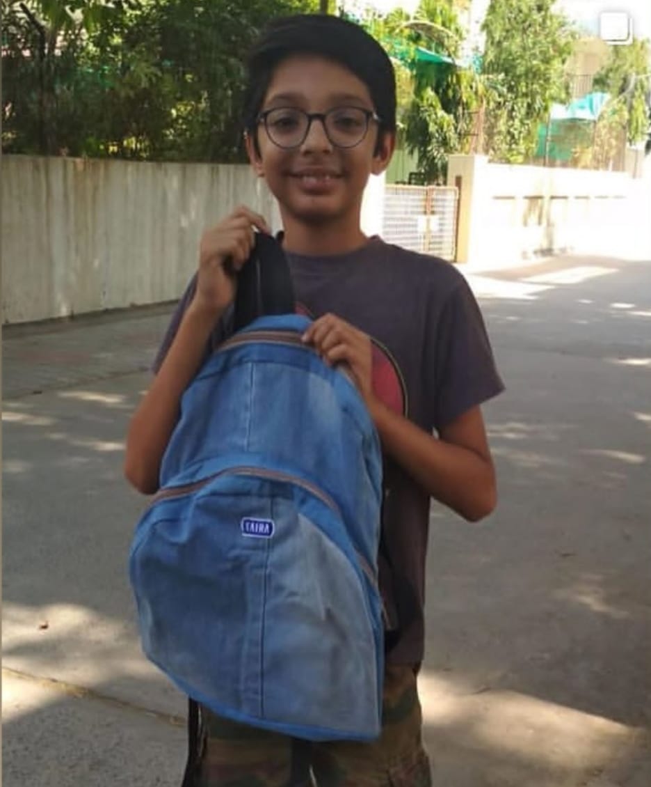 Young boy holding his denim backpack made from old jeans